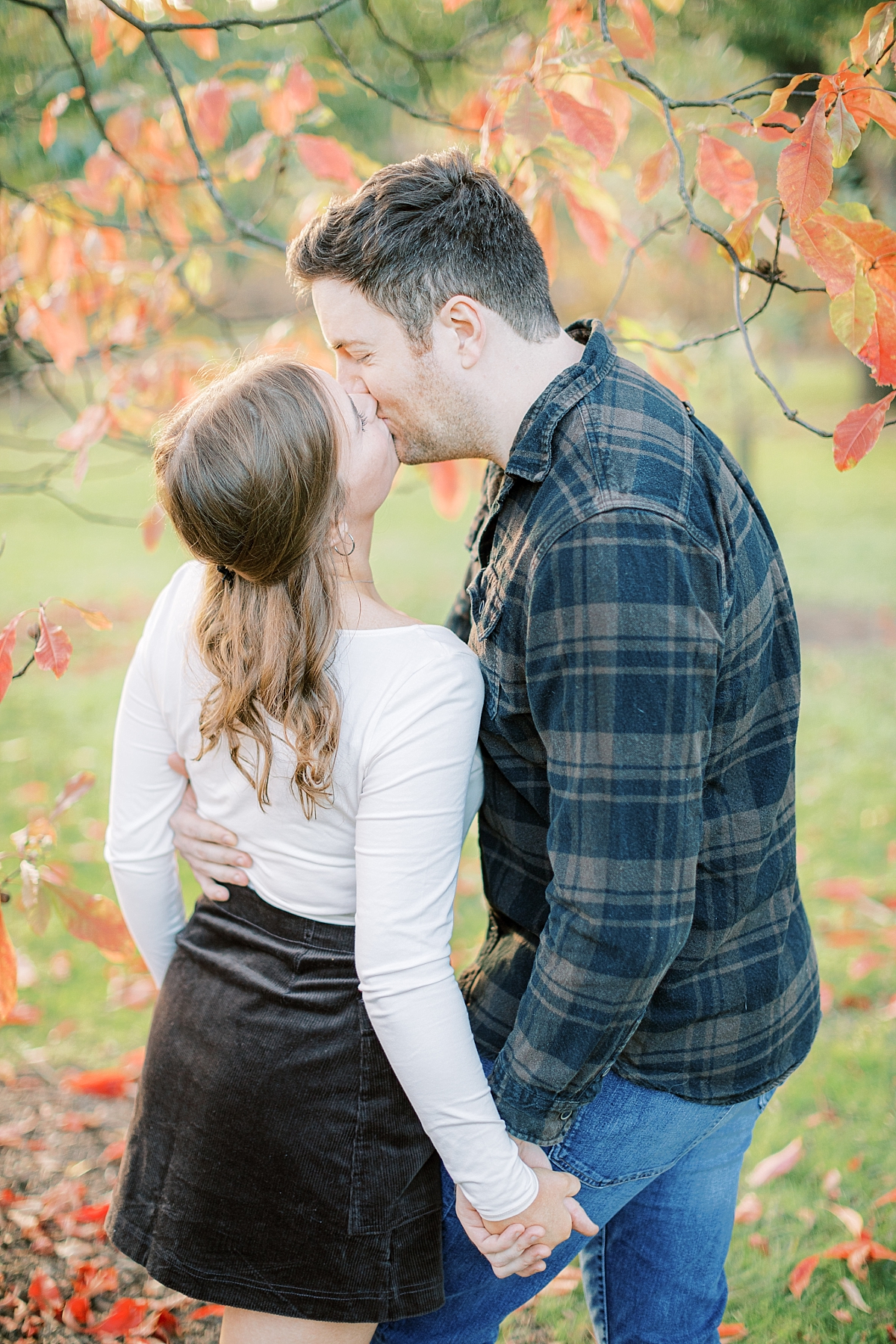 Longwood Gardens fall engagement session couple kissing by colorful tree