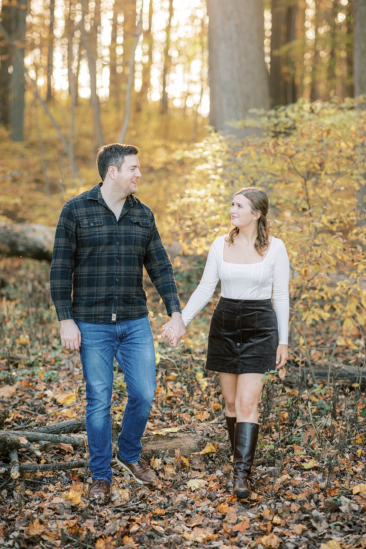 Longwood Gardens fall engagement session couple walking in woods