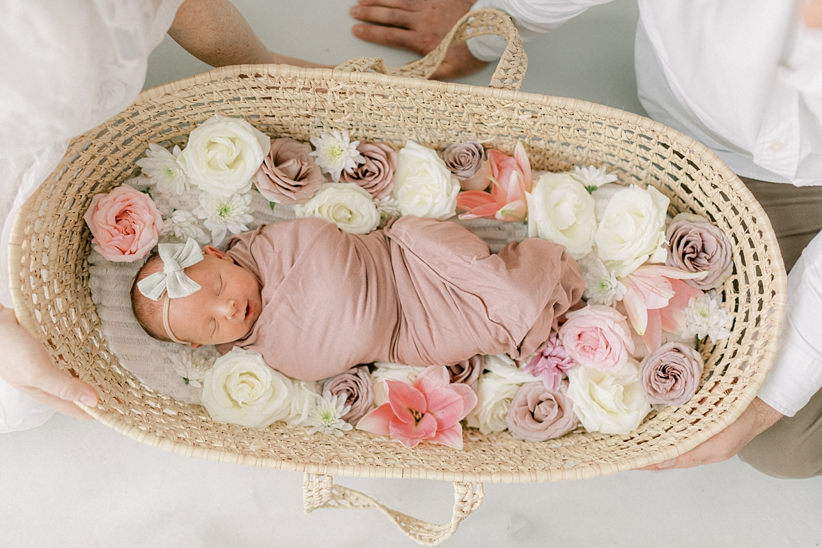 Baby girl in moses basket with flowers