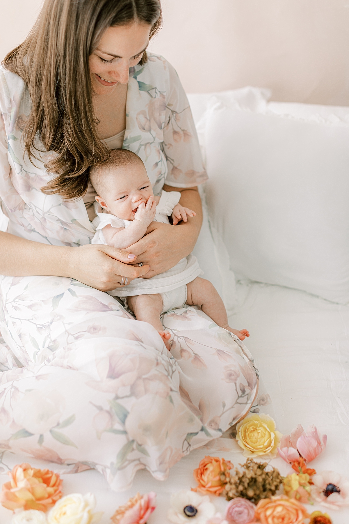 newborn girl on mom's lap with flowers