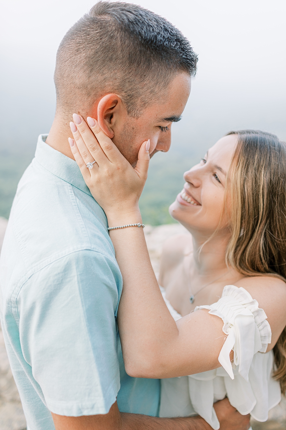 Engagement photo of a couple at Hawk Mountain Sanctuary in PA. The engagement ring is visible