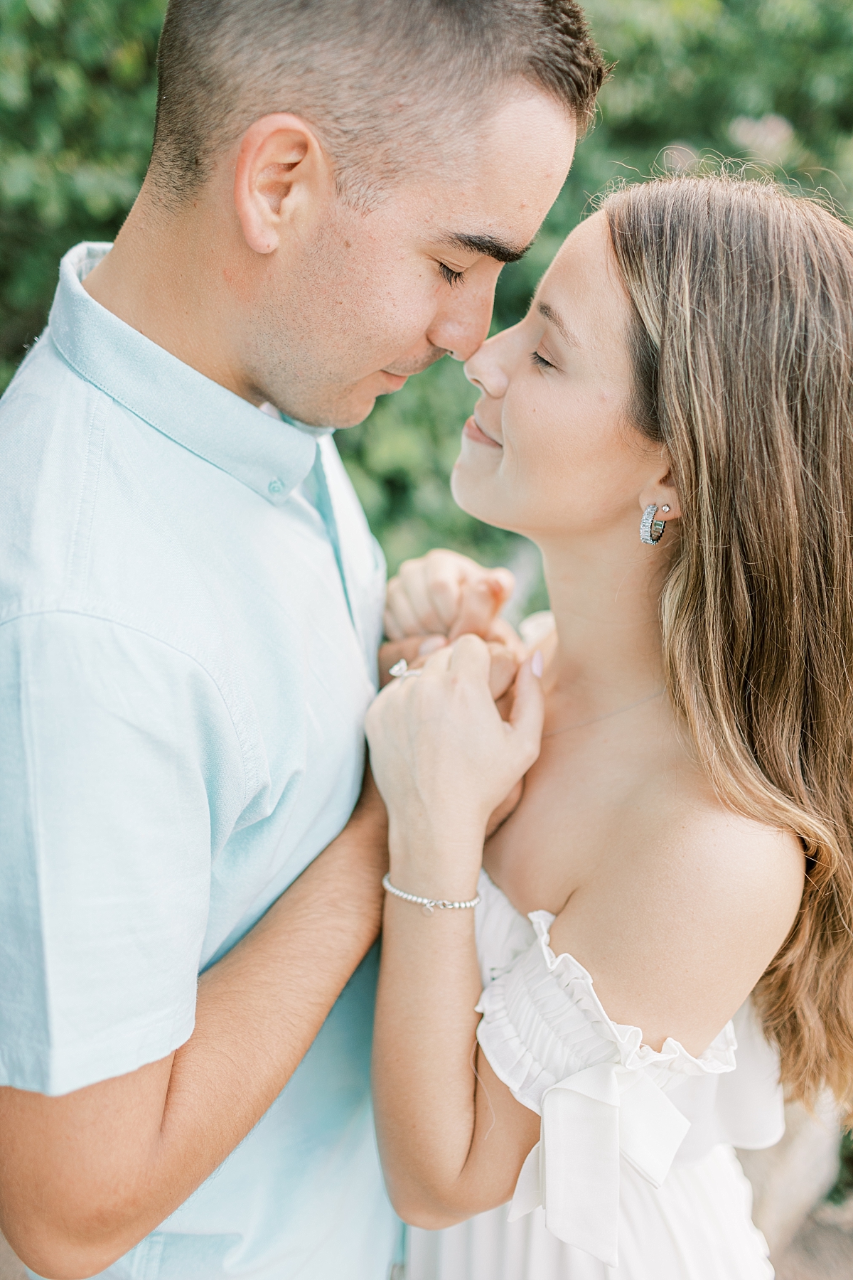 Engagement photo of a couple at Hawk Mountain Sanctuary in PA. The couple embraces and touches noses