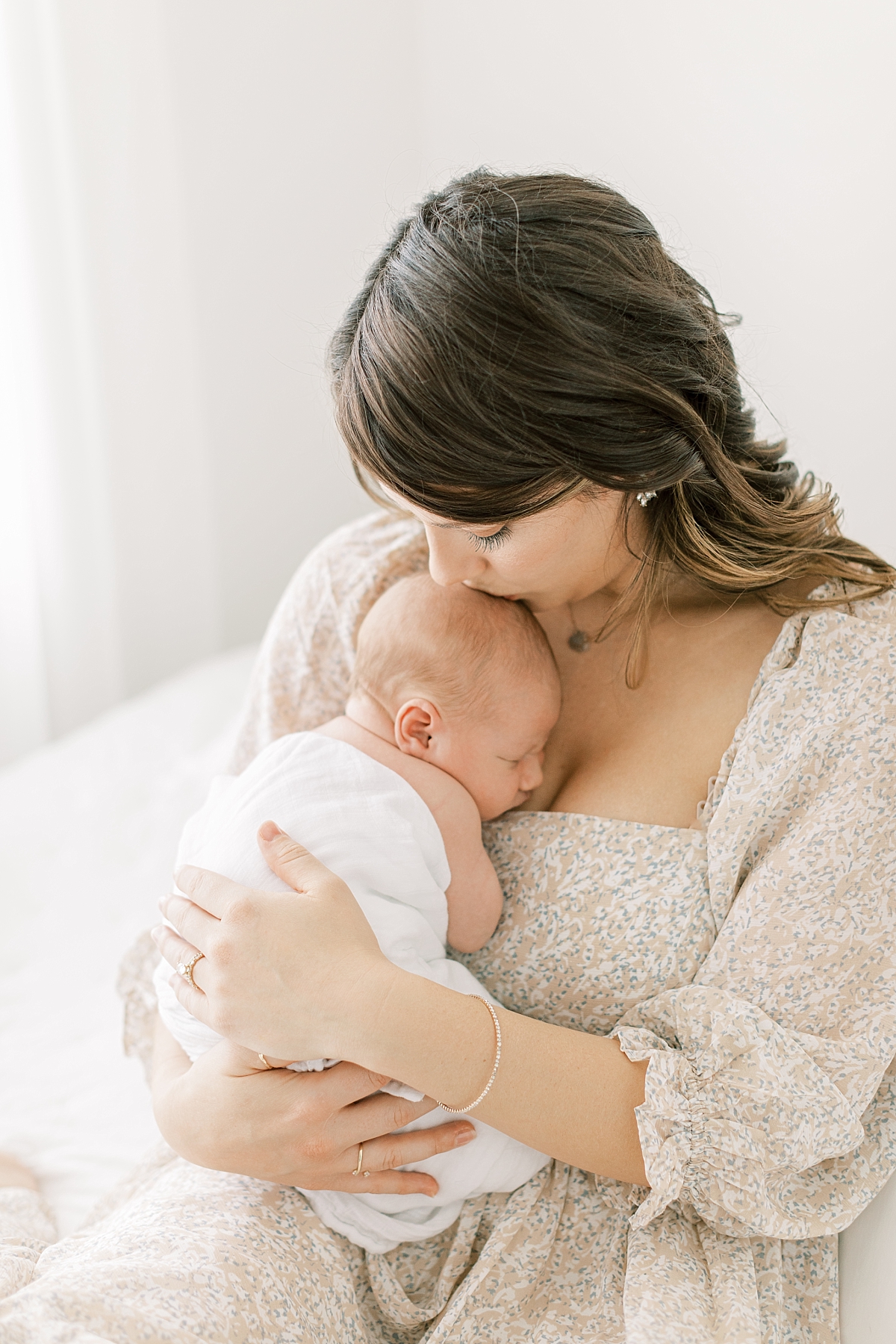 lifestyle newborn session with mom kissing baby's head
