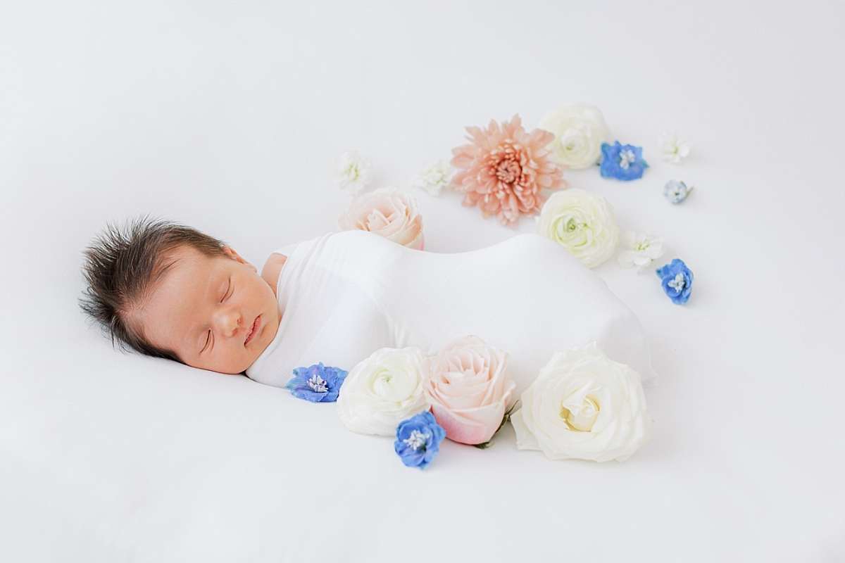newborn baby girl with blue and pink flowers