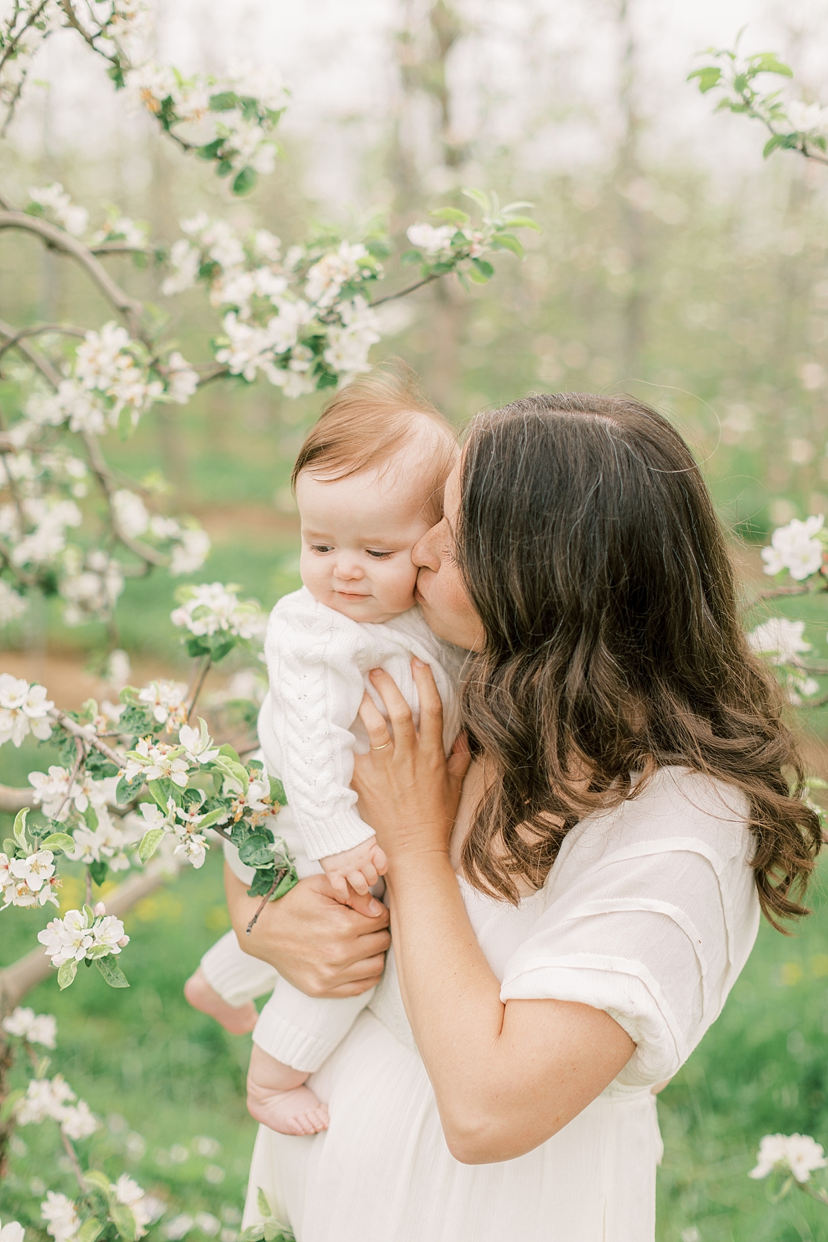 orchard newborn session with mom kissing baby