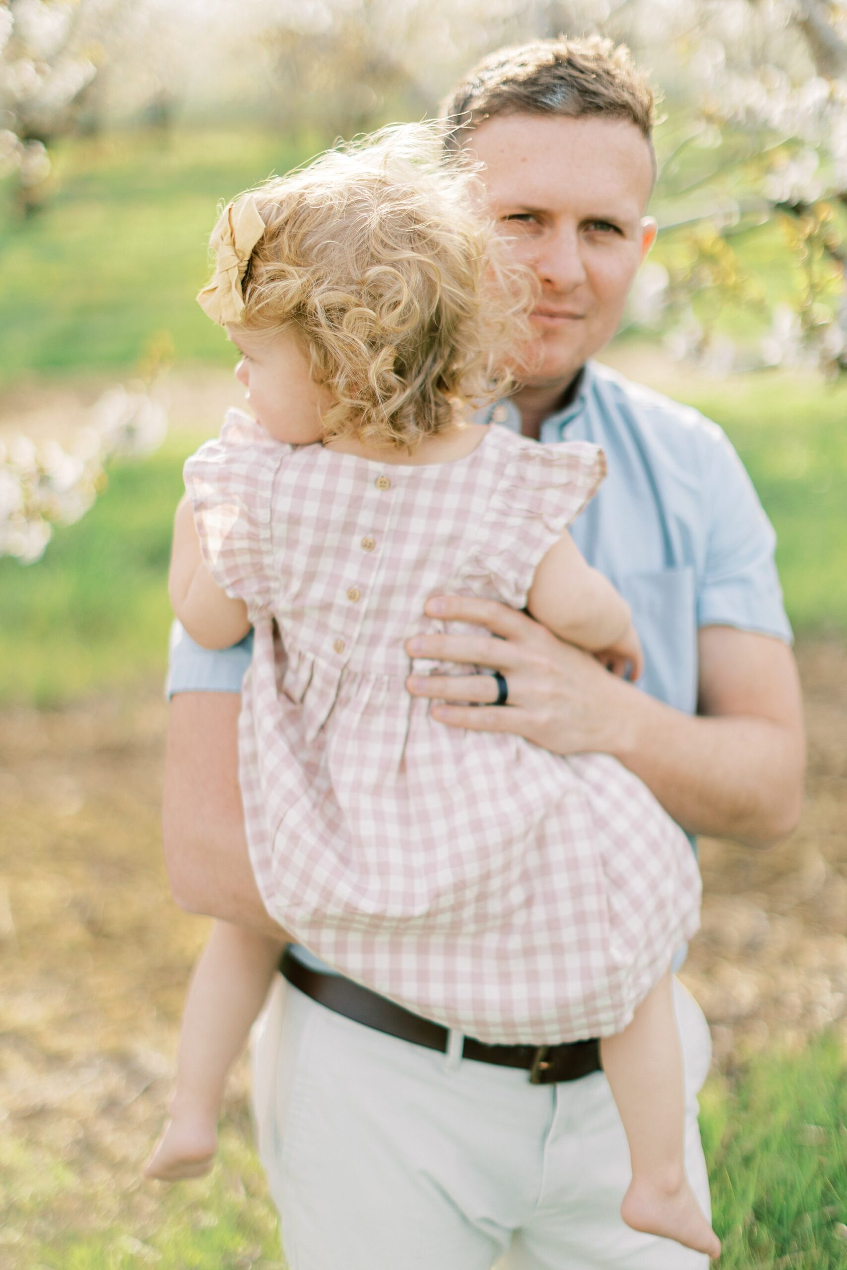 maternity session in an orchard in Lancaster county dad holding hdaughter